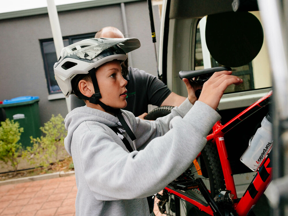 Kid loading a bike into a van